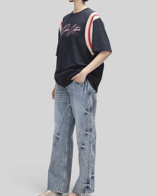 Baffle Haus Debute Tee in black with red and cream striped sleeve inserts and front embroidery on a model.