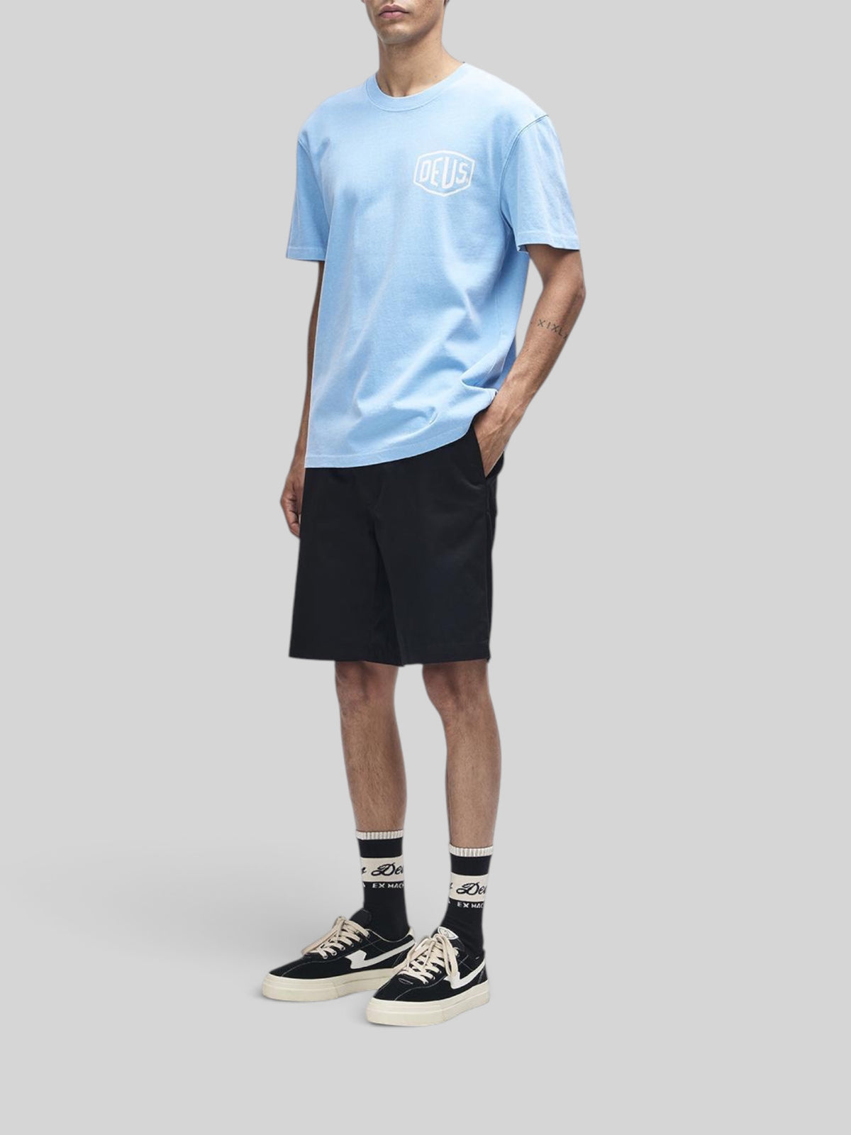 Baffle Haus model wearing a light blue Deus Shield garment dyed heavyweight recycled cotton box fit t-shirt