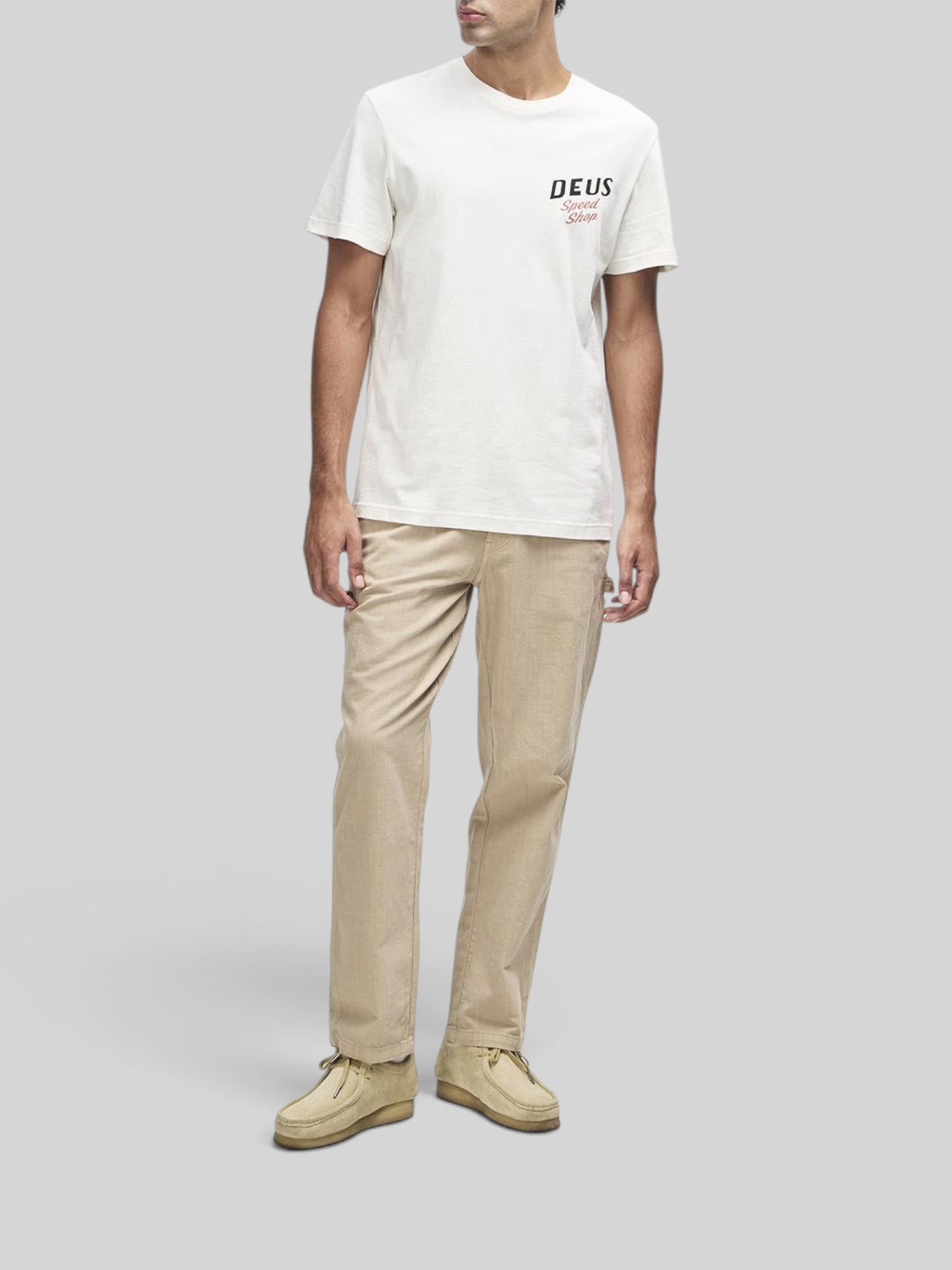 Baffle Haus model wearing a dirty white regular fit short sleeve tee with Deus Speed Shop chest graphic