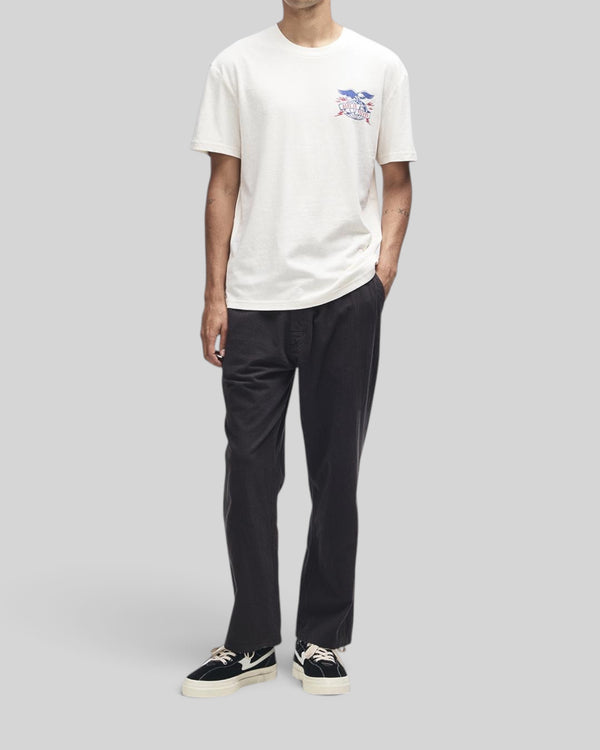 Baffle Haus model wearing a dirty white box fit t-shirt with graphic chest print and recycled cotton blend fabric.