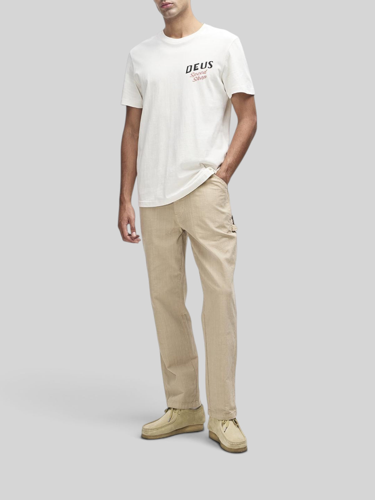 Baffle Haus Dogleg Tee in dirty white organic cotton with Deus Speed Shop chest graphic on a male model