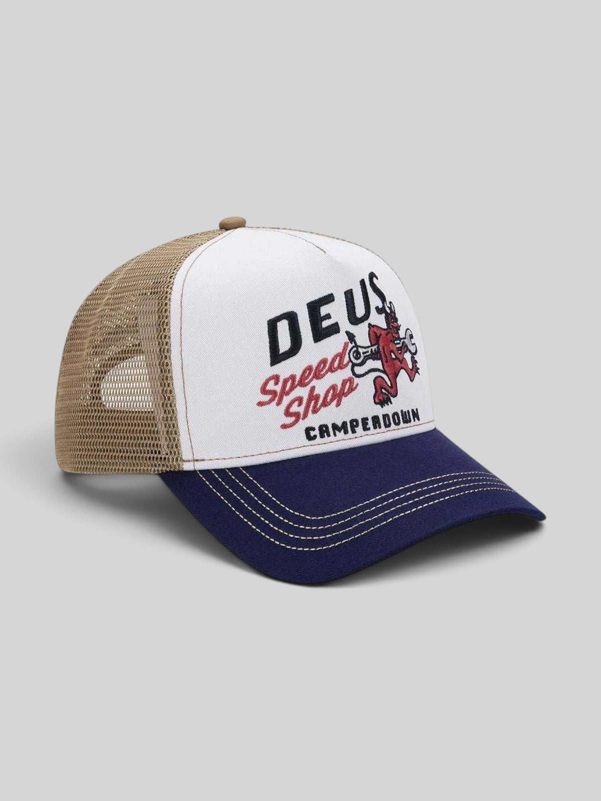 Baffle Haus Dogleg Trucker hat in dirty white with a navy brim, mesh back, and Deus Speed Shop graphic print
