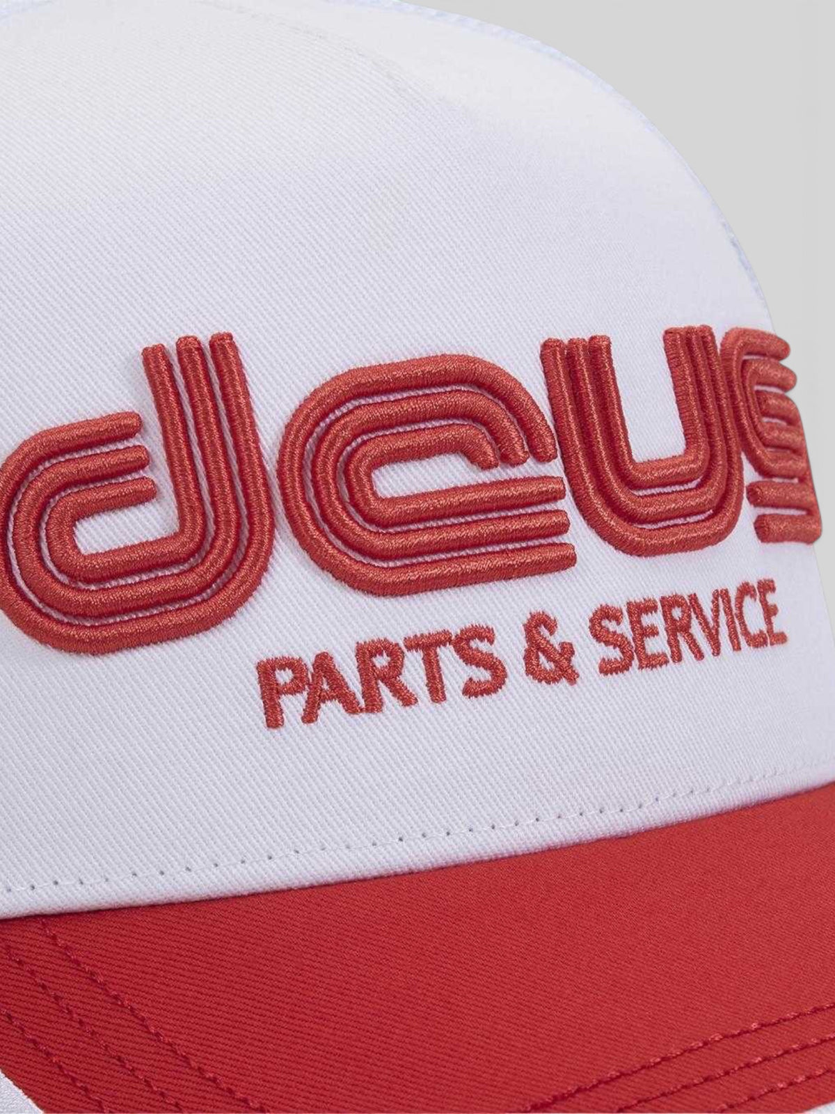Baffle Haus Double Track Trucker hat in vintage white with red embroidered Deus Parts & Service logo and red visor