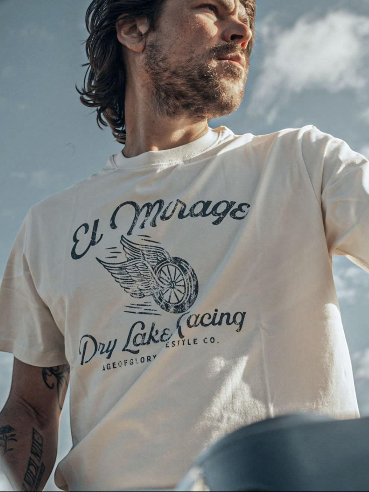 Baffle Haus off-white cotton t-shirt featuring a vintage El Mirage dry lake racing graphic with a winged wheel