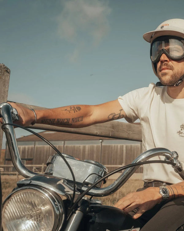 Baffle Haus Fine Art ecru cotton t-shirt worn by a man in a vintage helmet on a motorcycle