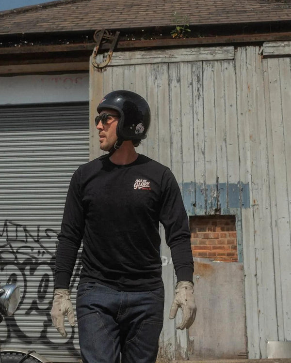 Baffle Haus Fine Arts black long sleeve cotton tee with screen printed chest logo worn by a man in a motorcycle helmet