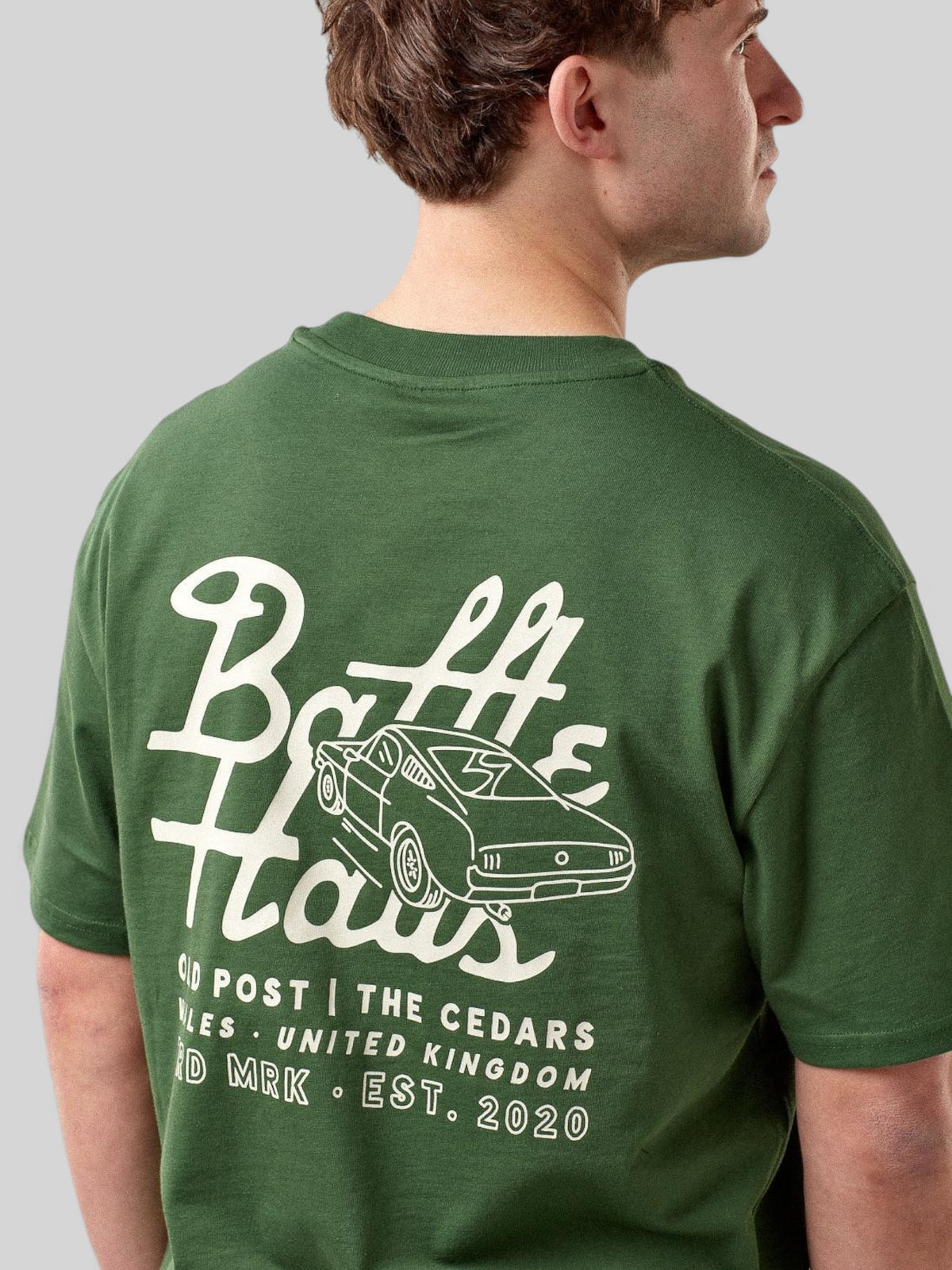 Baffle Haus forest green cotton t-shirt with white mustang car graphic on the back worn by a male model