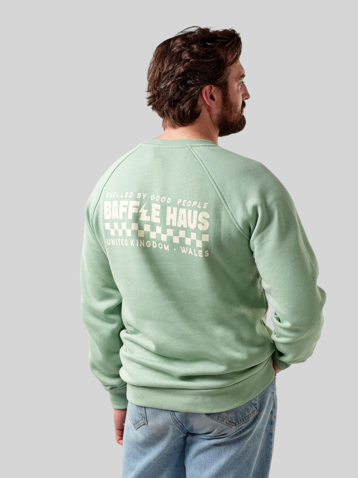 Back view of a man wearing a Baffle Haus granite green heavyweight cotton-blend sweatshirt with a graphic print.