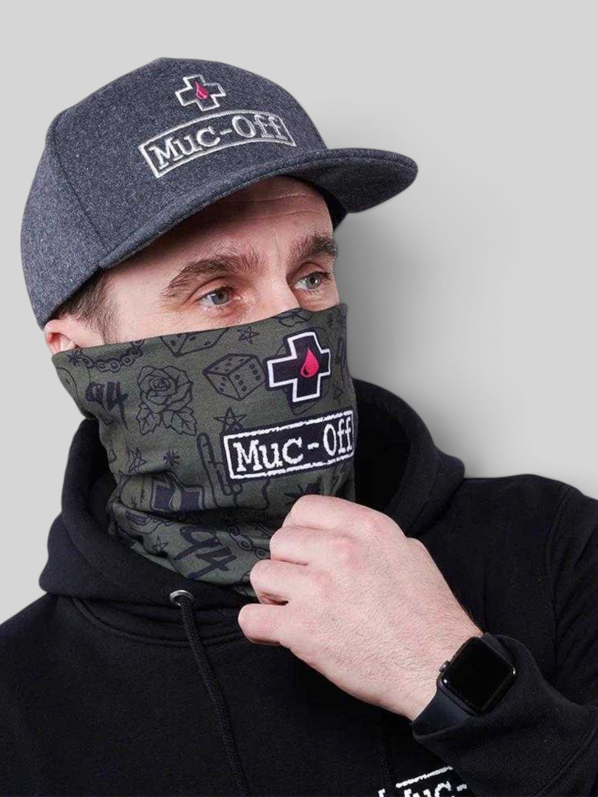 Baffle Haus green punk print lightweight polyester neck gaiter worn by a man in a black hoodie and grey cap