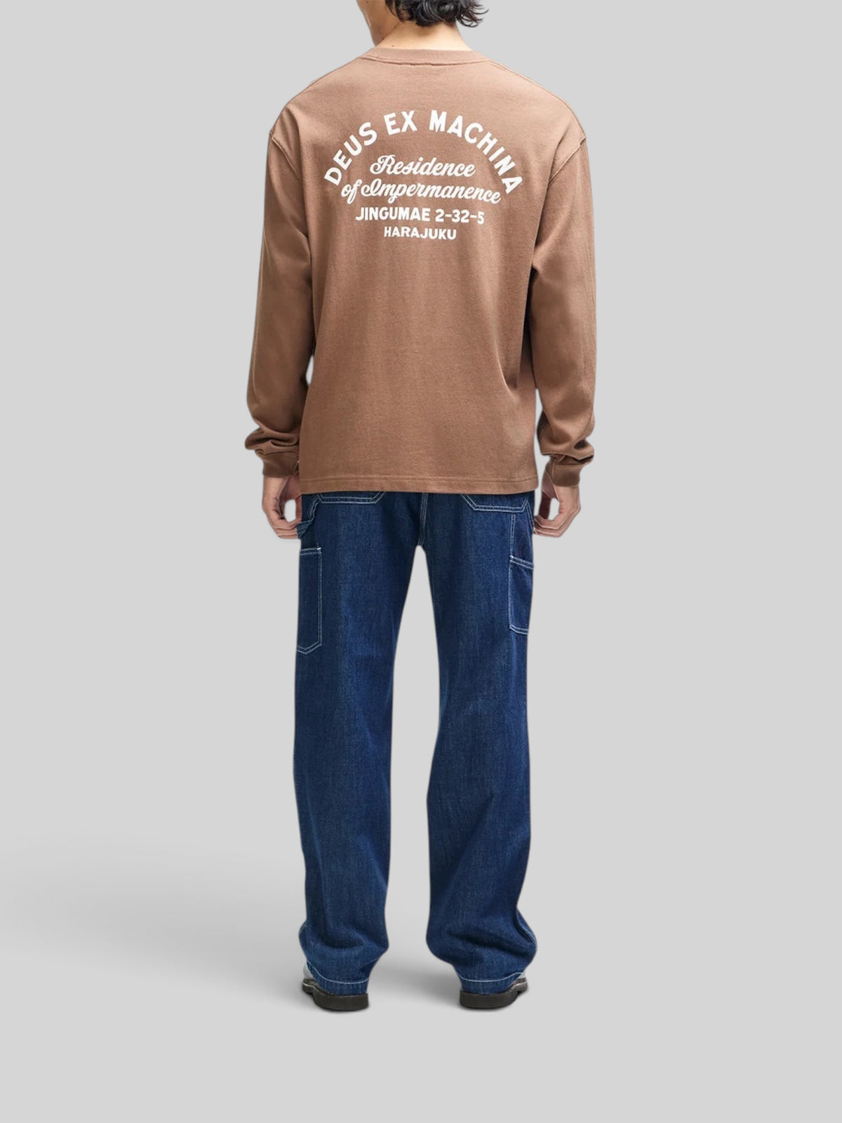 Baffle Haus Harajuku long sleeve tee in bison brown with white graphic print on back, worn by a model in jeans