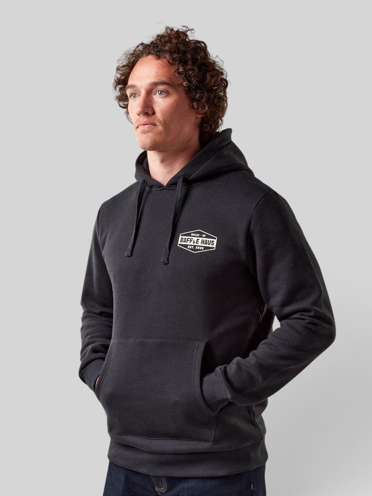 Baffle Haus jet black heavyweight cotton blend hoodie with white chest logo on a male model
