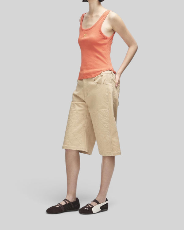 Baffle Haus June Shield tank in flame orange with thin straps, curved hem, and chest embroidery on a model.