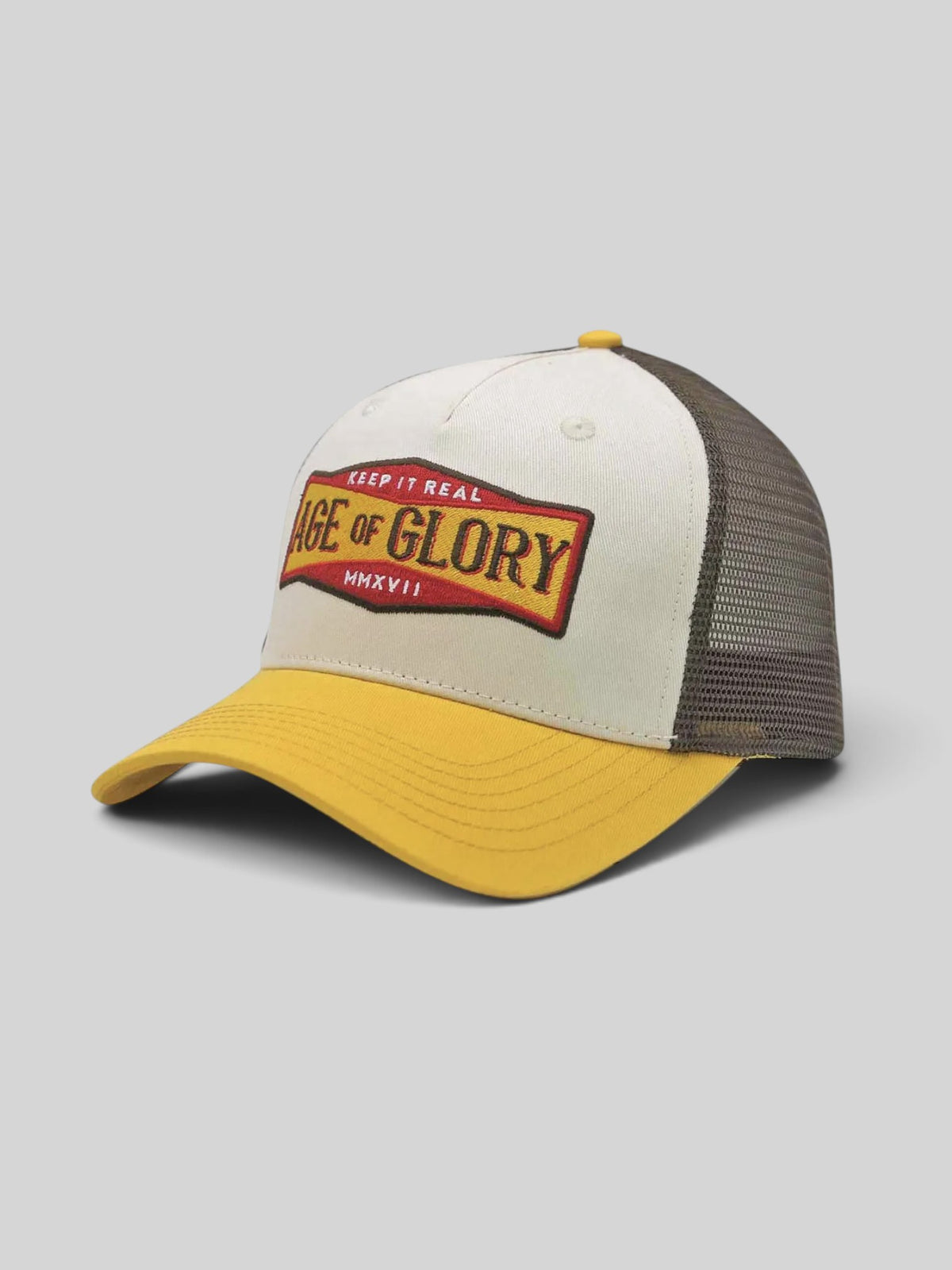 Baffle Haus Keep It Real trucker cap in white and yellow with a vintage graphic patch and brown mesh back panel.