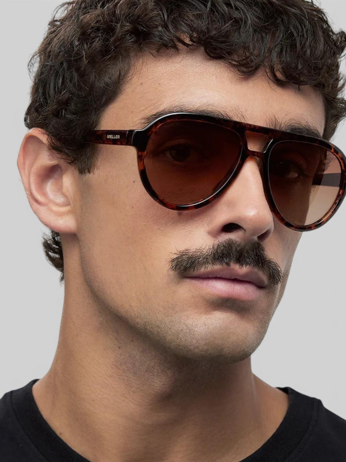Baffle Haus KENA sunglasses in Tigris brown with an aviator silhouette and polarized lenses worn by a man.