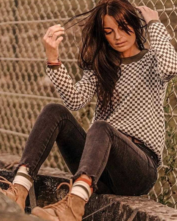 Baffle Haus khaki knitted jumper with a black and white checkerboard pattern, ribbed collar, and cuffs.