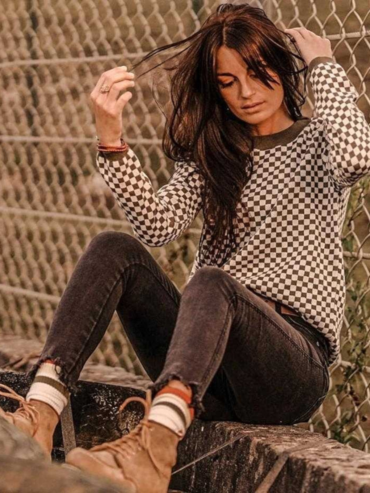 Baffle Haus khaki knitted jumper with a black and white checkerboard pattern, ribbed collar, and cuffs.
