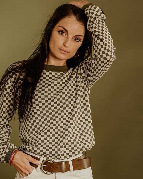 Baffle Haus khaki knitted jumper with a retro checkerboard pattern, ribbed collar, and cuffs worn by a woman