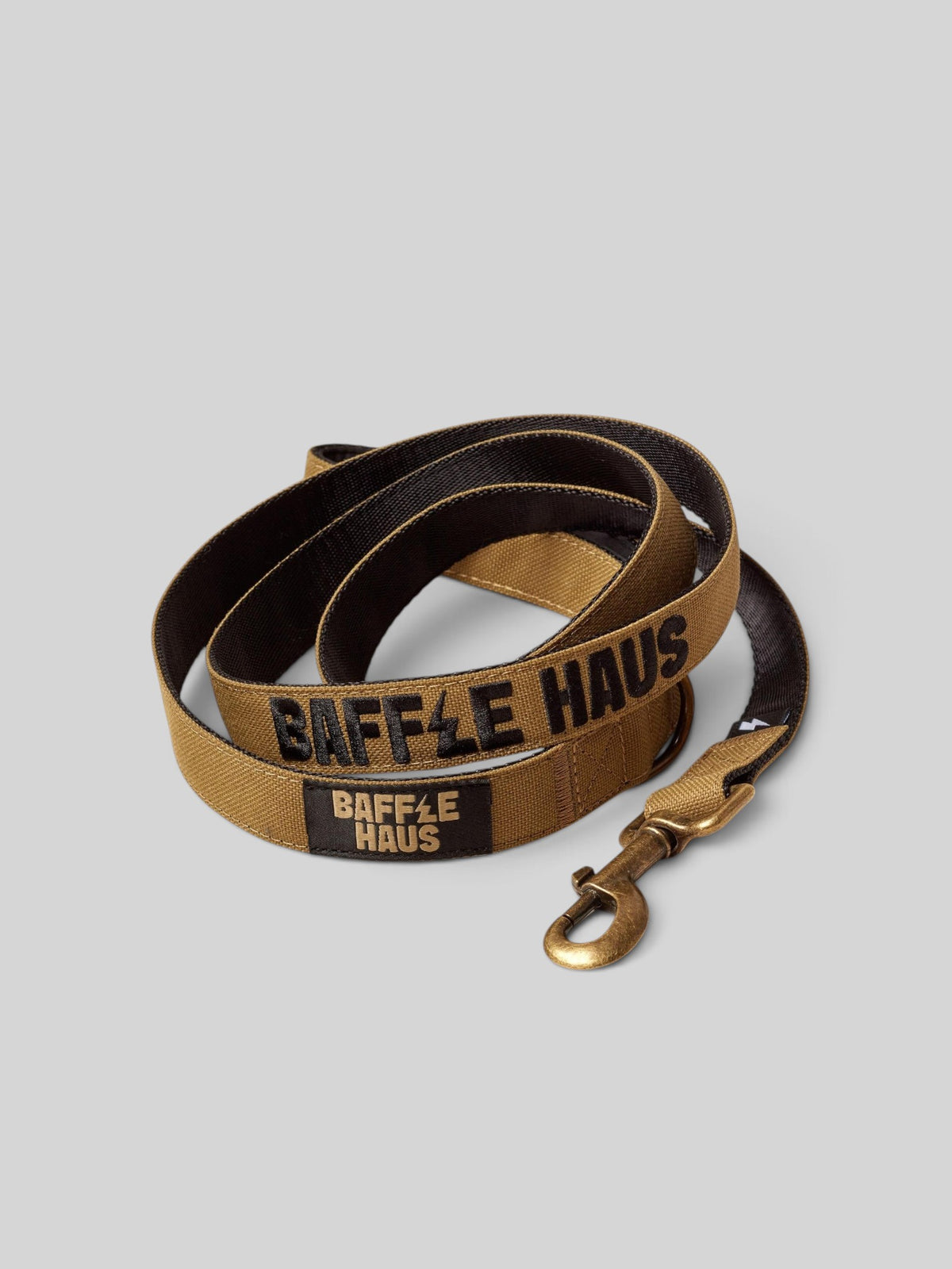 Baffle Haus 5ft khaki nylon dog lead with black branding, swivel clip, and padded handle on a grey background.