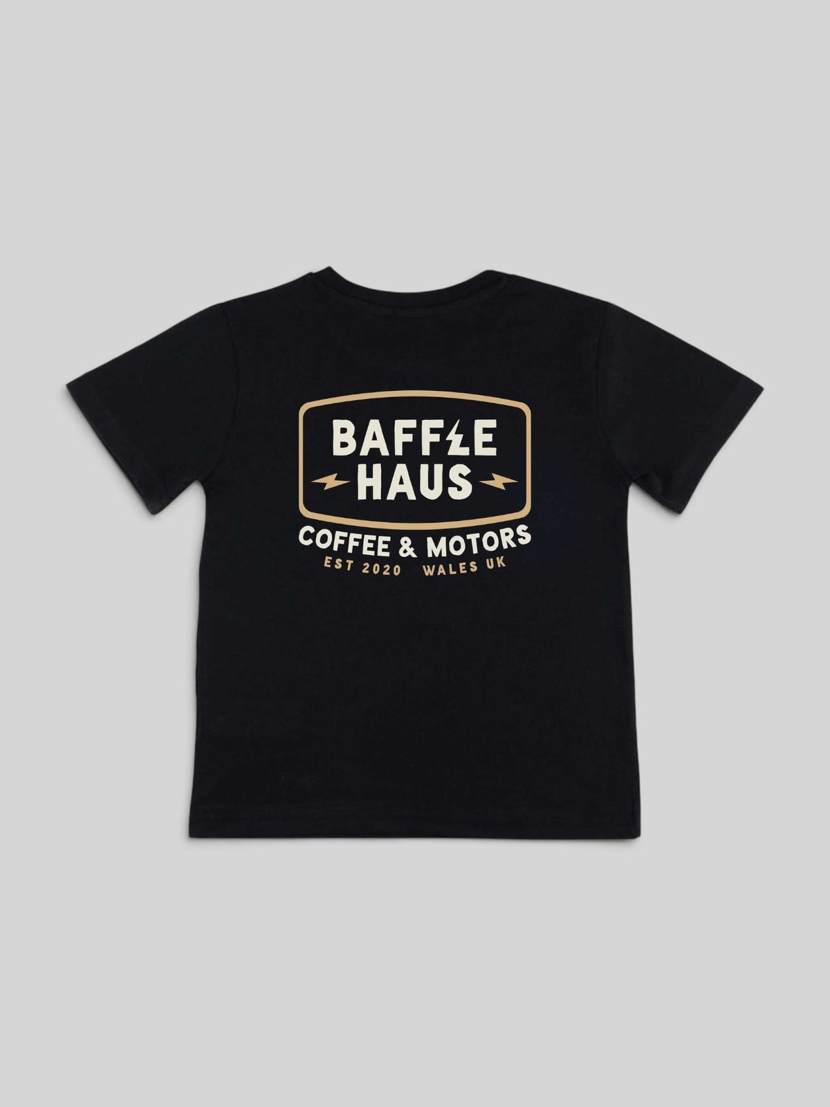 Back view of a black Baffle Haus kids cotton t-shirt featuring a Coffee & Motors graphic print in cream and white.