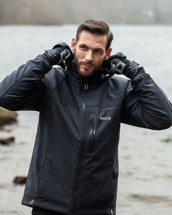 Baffle Haus Knox Dual Pro 3-in-1 black motorcycle soft-shell jacket worn by a man adjusting his collar by a lake.