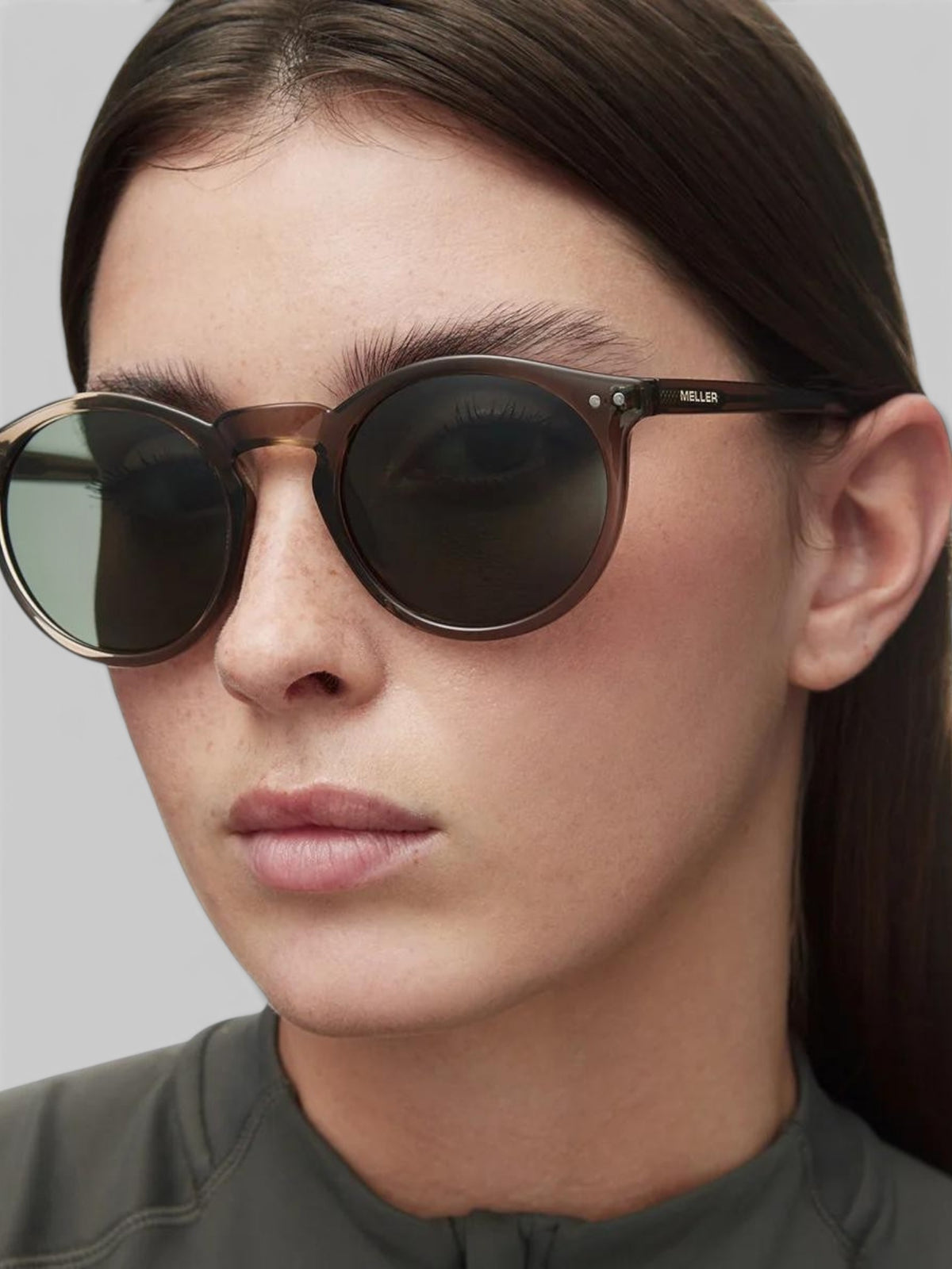 Baffle Haus KUBU sunglasses with vintage rounded camel frames and olive polarized lenses on a woman