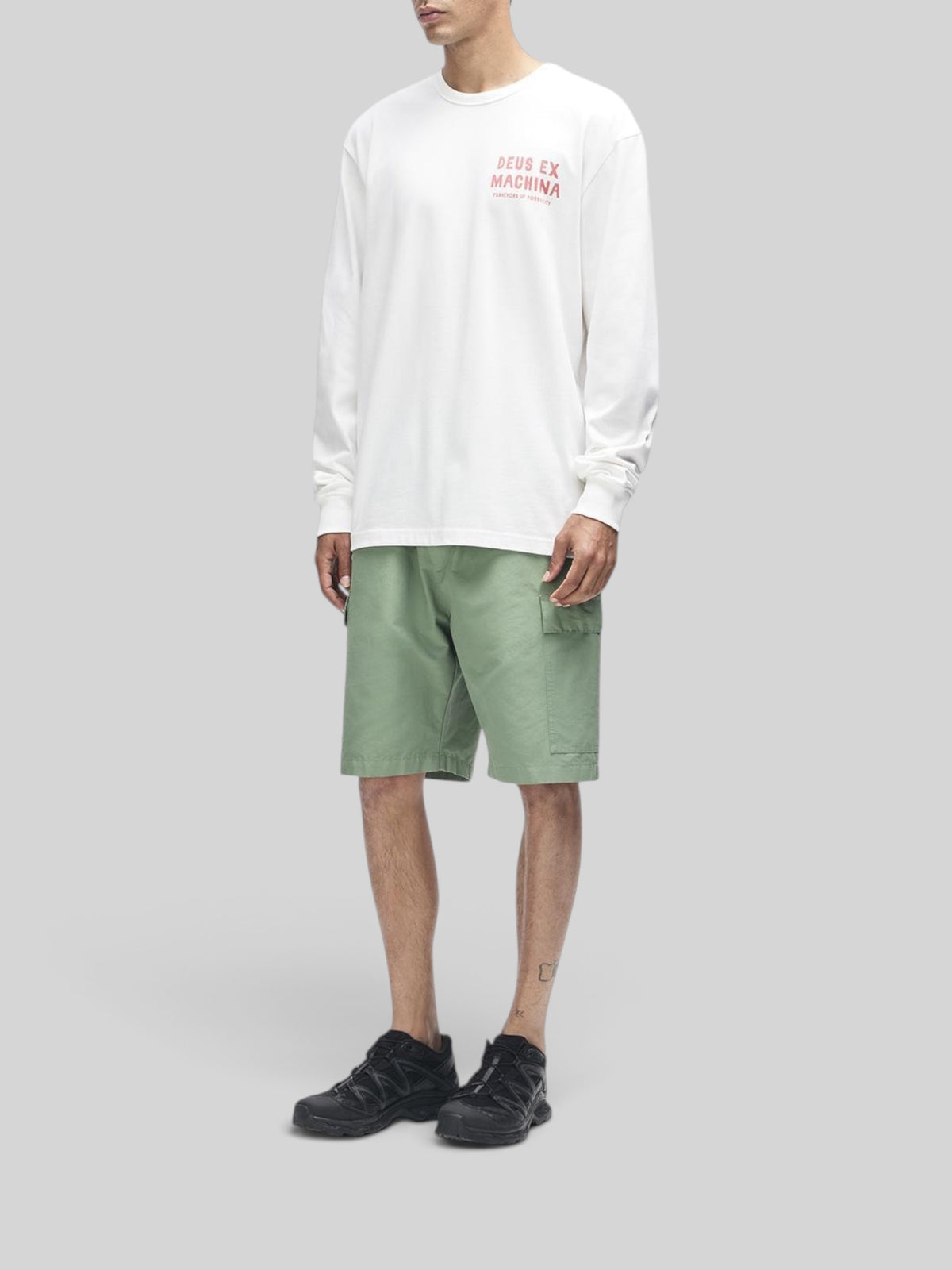 Baffle Haus Kumbaya long sleeve tee in vintage white with chest graphic, paired with green cargo shorts