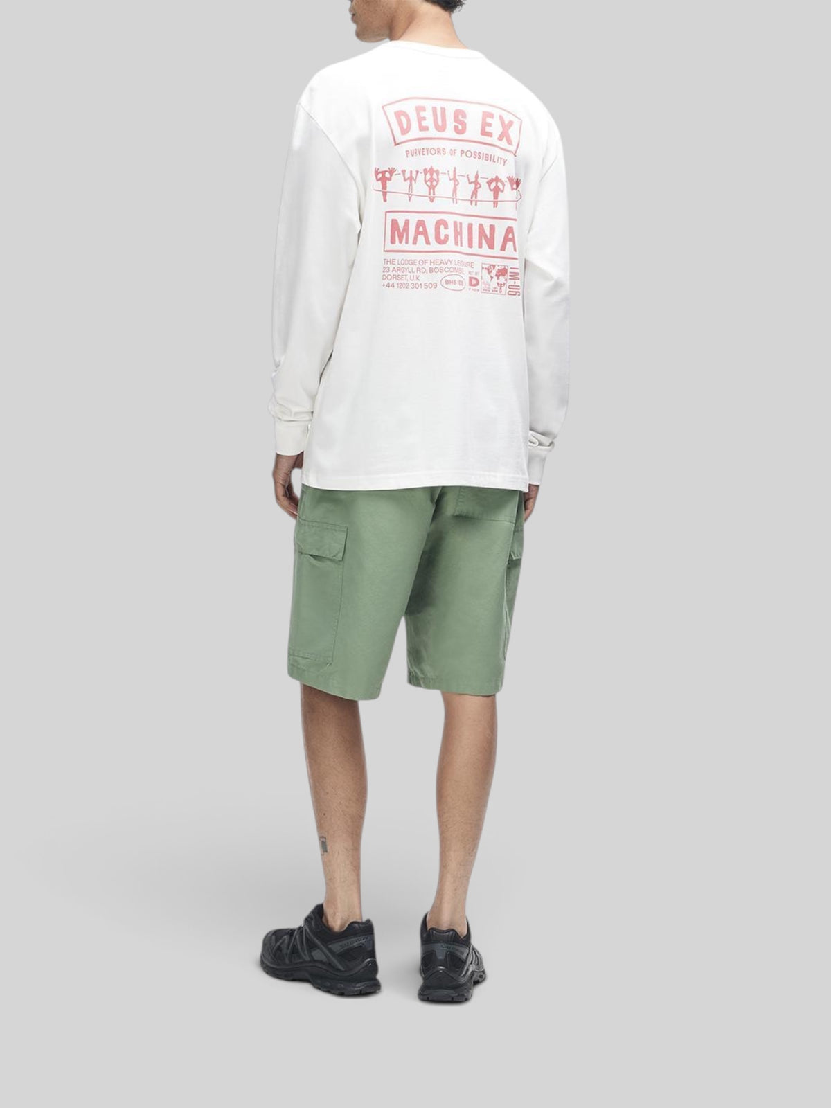 Baffle Haus Kumbaya long sleeve tee in vintage white with red graphic print on back, paired with olive cargo shorts