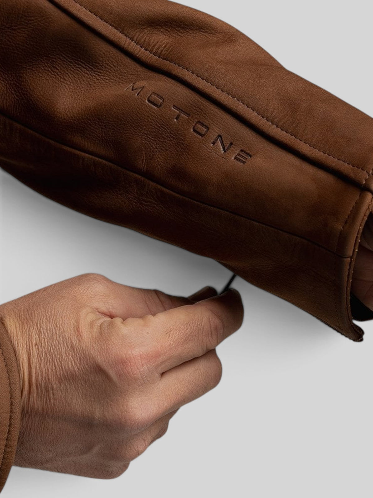 Baffle Haus Motone Shōgun mahogany nubuck leather jacket sleeve detail with embossed branding and zipper cuff