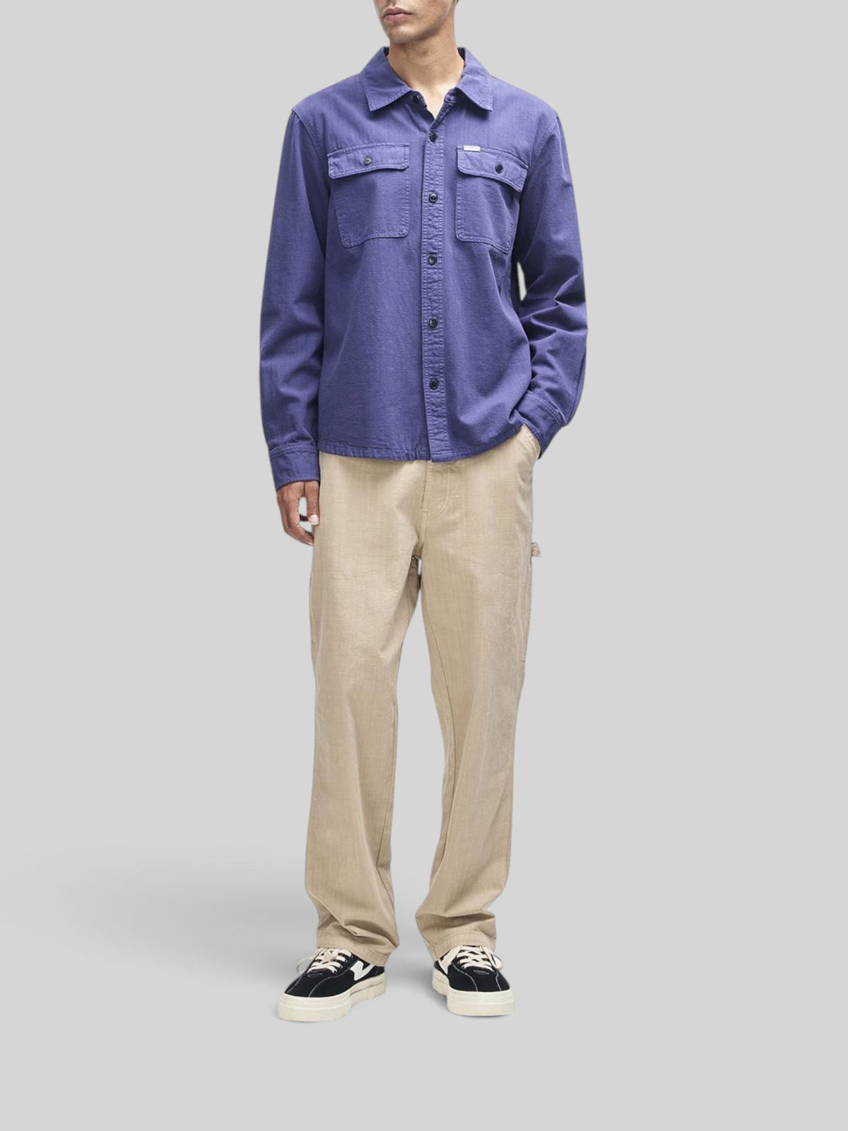 Baffle Haus Vacay Chambray Shirt in mechanic blue worn with beige trousers and sneakers on a model