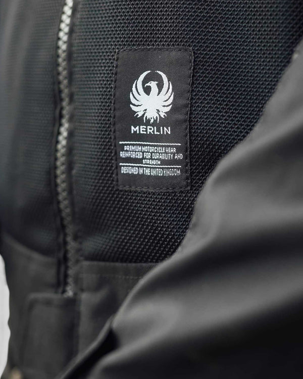 Close-up of the Baffle Haus Merlin Prospect black mesh motorcycle jacket showing the branded chest patch and fabric
