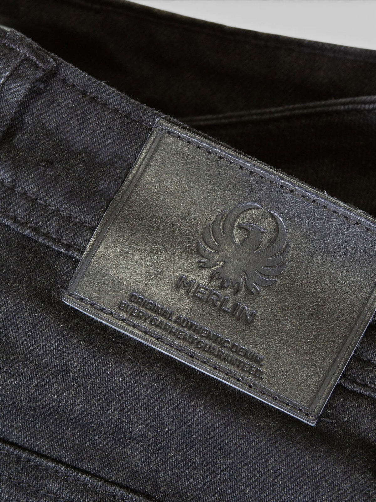 Baffle Haus Merlin Rivington black motorcycle jeans featuring a branded leather belt patch with embossed logo