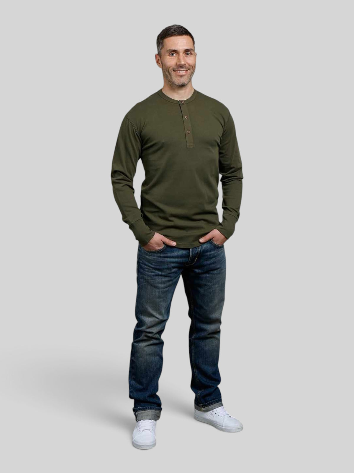 Baffle Haus 1927 Henley long sleeve shirt in Mojave green cotton with coconut buttons worn by a smiling man