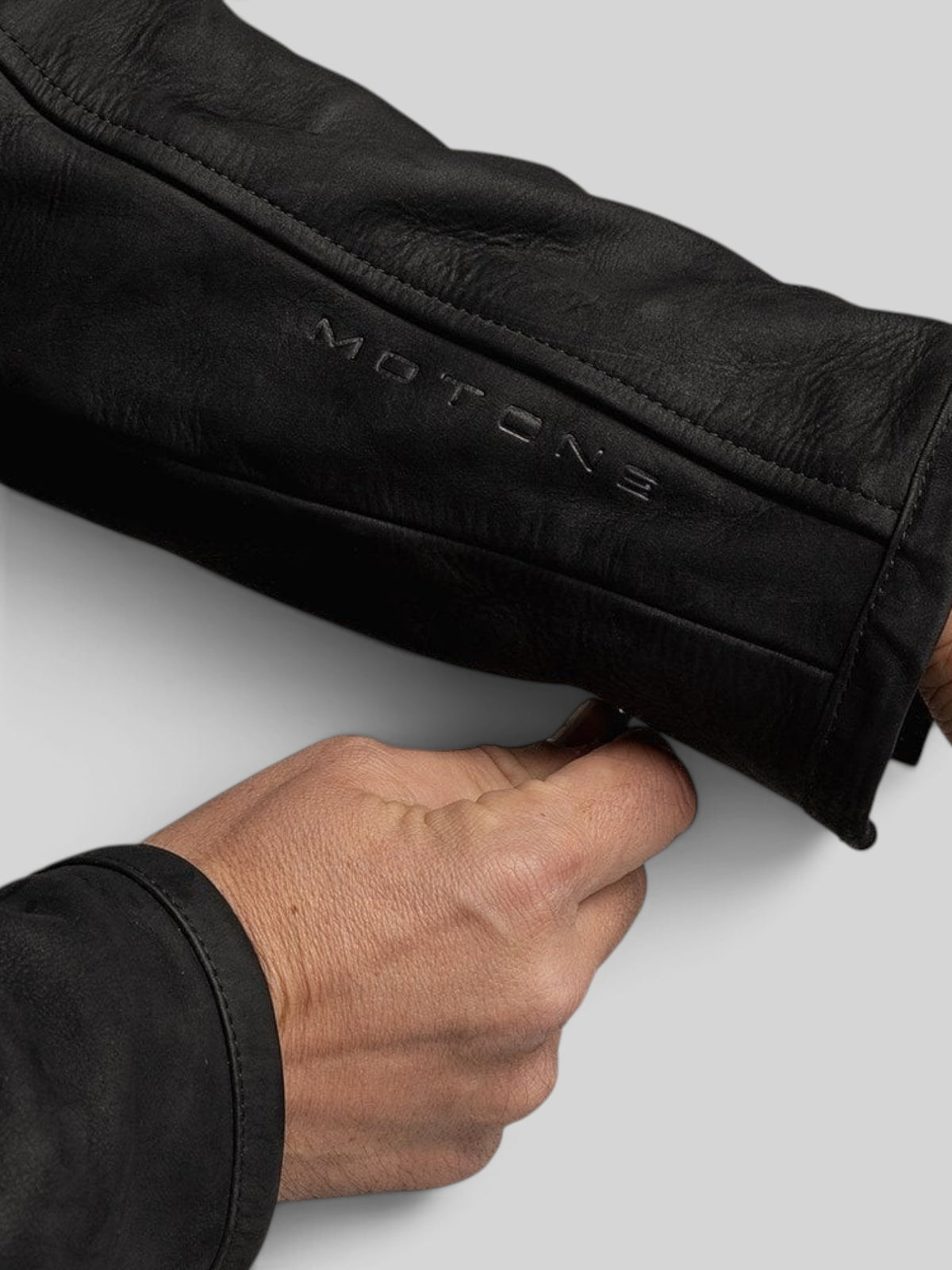 Baffle Haus Motone Shōgun black nubuck leather motorcycle jacket sleeve detail with embossed branding and zipper cuff