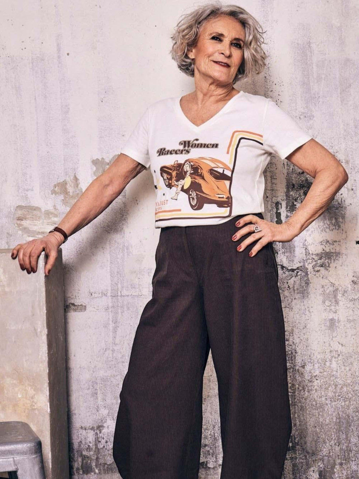 Baffle Haus Motor Club white V-neck cotton T-shirt with retro racing graphic worn by a woman