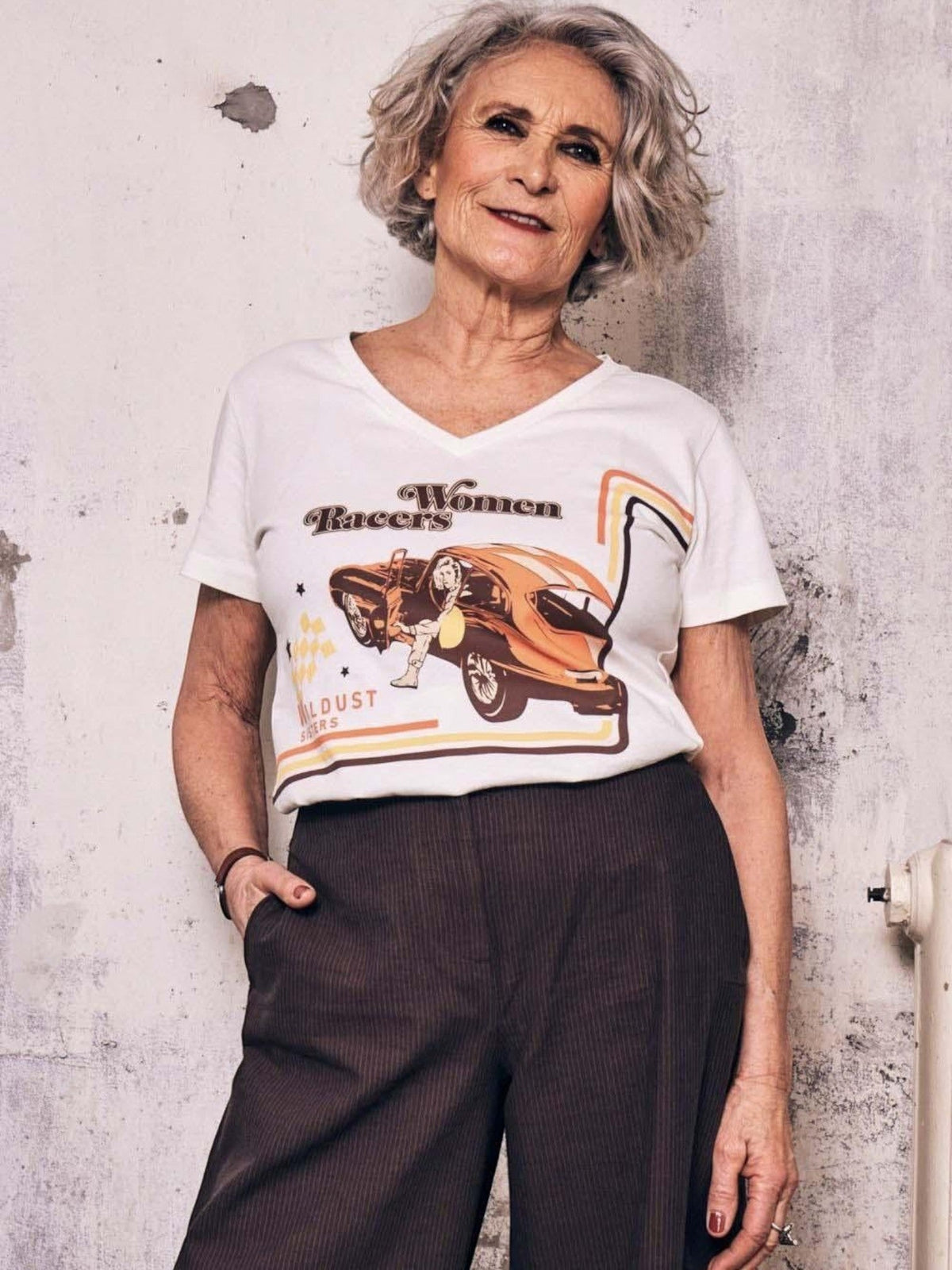 Baffle Haus Motor Club white V-neck cotton T-shirt featuring a retro women racers graphic print on a mature model.