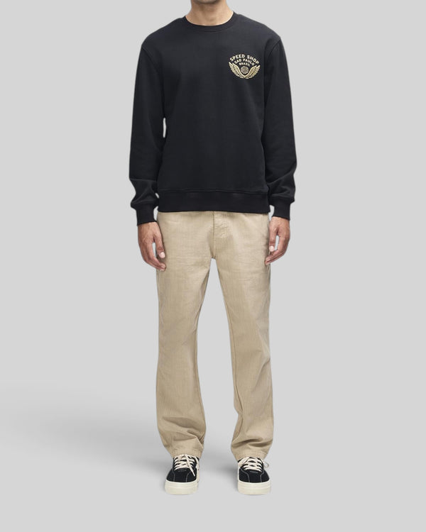 Baffle Haus Munificence crew neck fleece in black with chest graphic, ribbed cuffs, and hem on a male model.