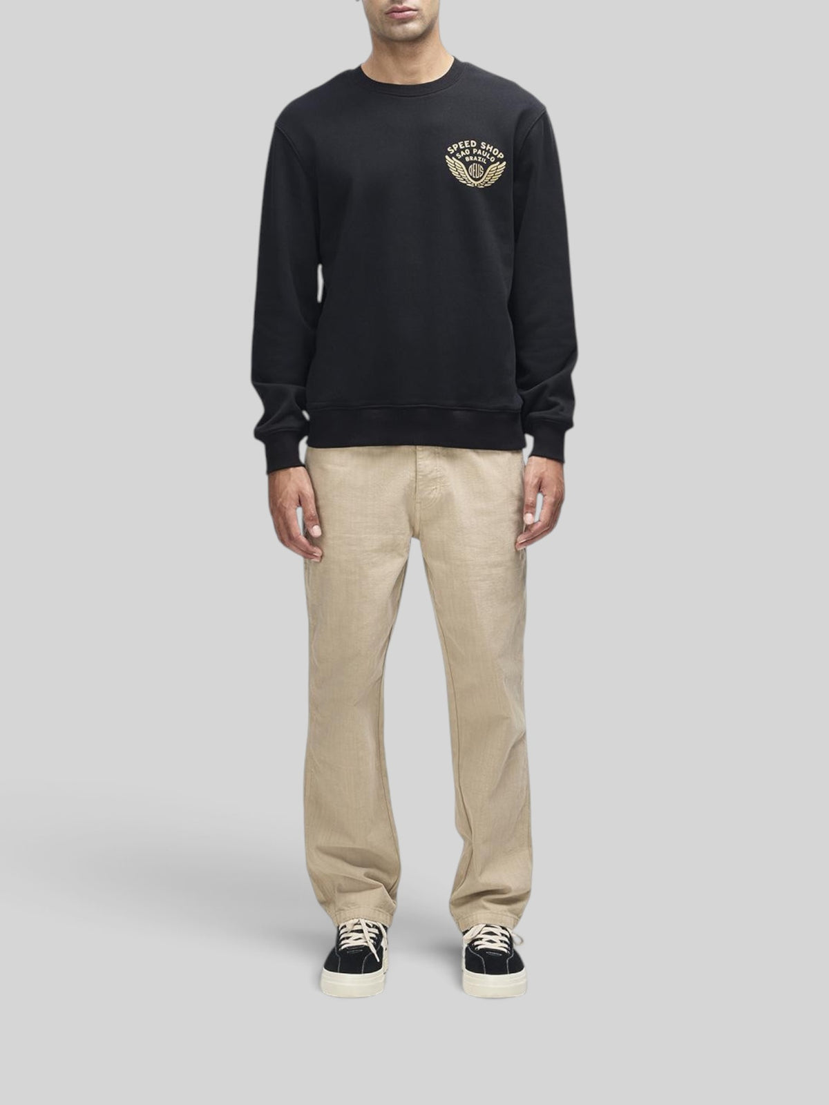 Baffle Haus Munificence crew neck fleece in black with chest graphic, ribbed cuffs, and hem on a male model.
