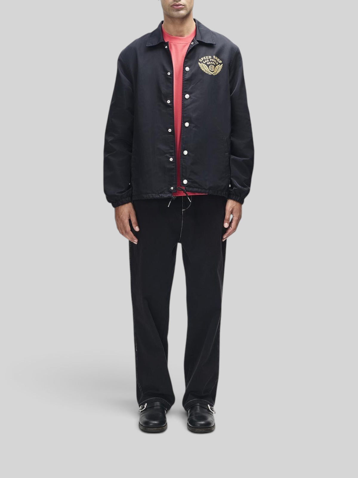 Baffle Haus Munificence black recycled nylon coach jacket with chest graphic and snap button closure