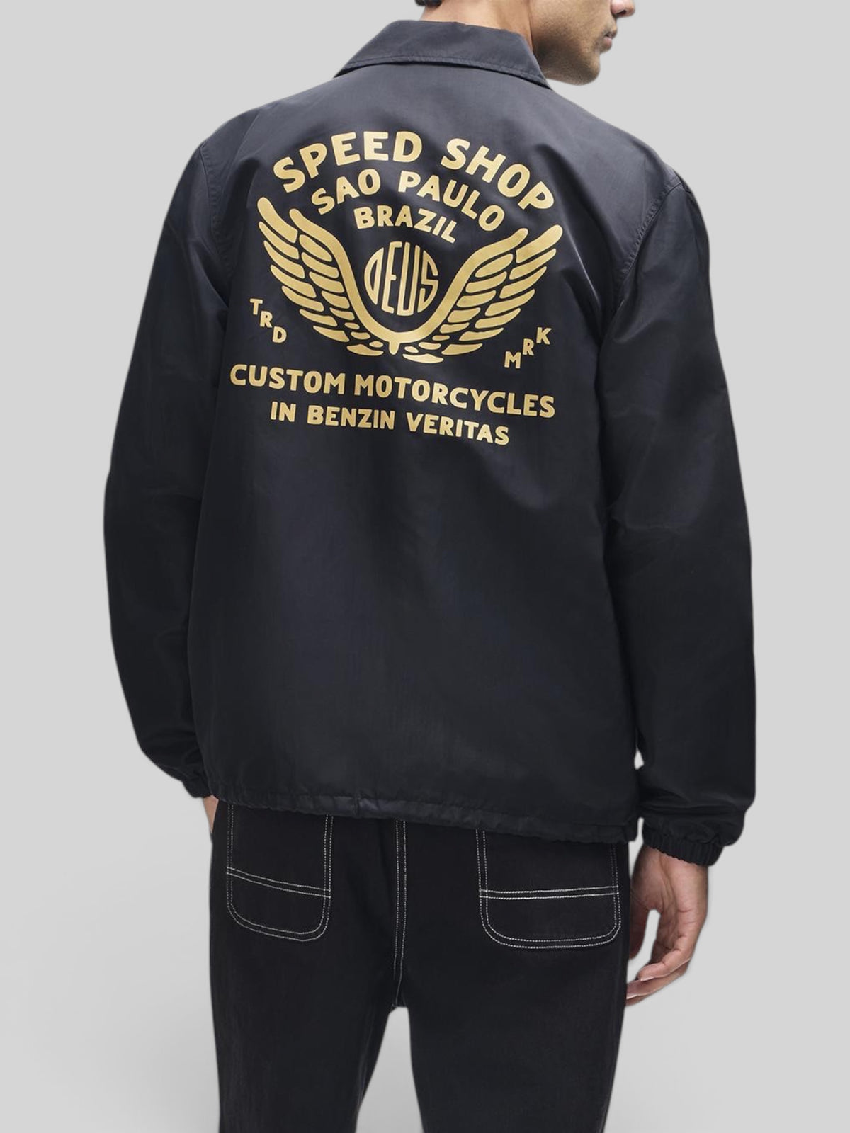 Baffle Haus Munificence black recycled nylon coach jacket with gold graphic print on the back