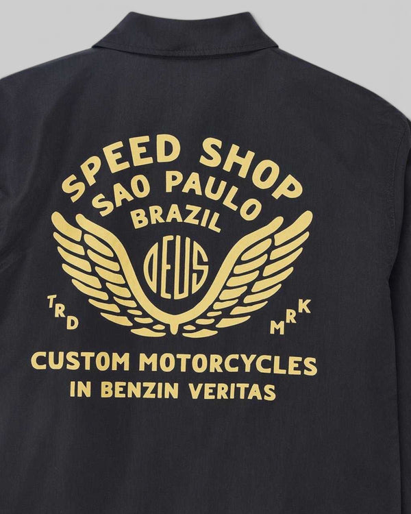 Baffle Haus Munificence black nylon coach jacket featuring gold Deus Speed Shop Sao Paulo graphic print on the back