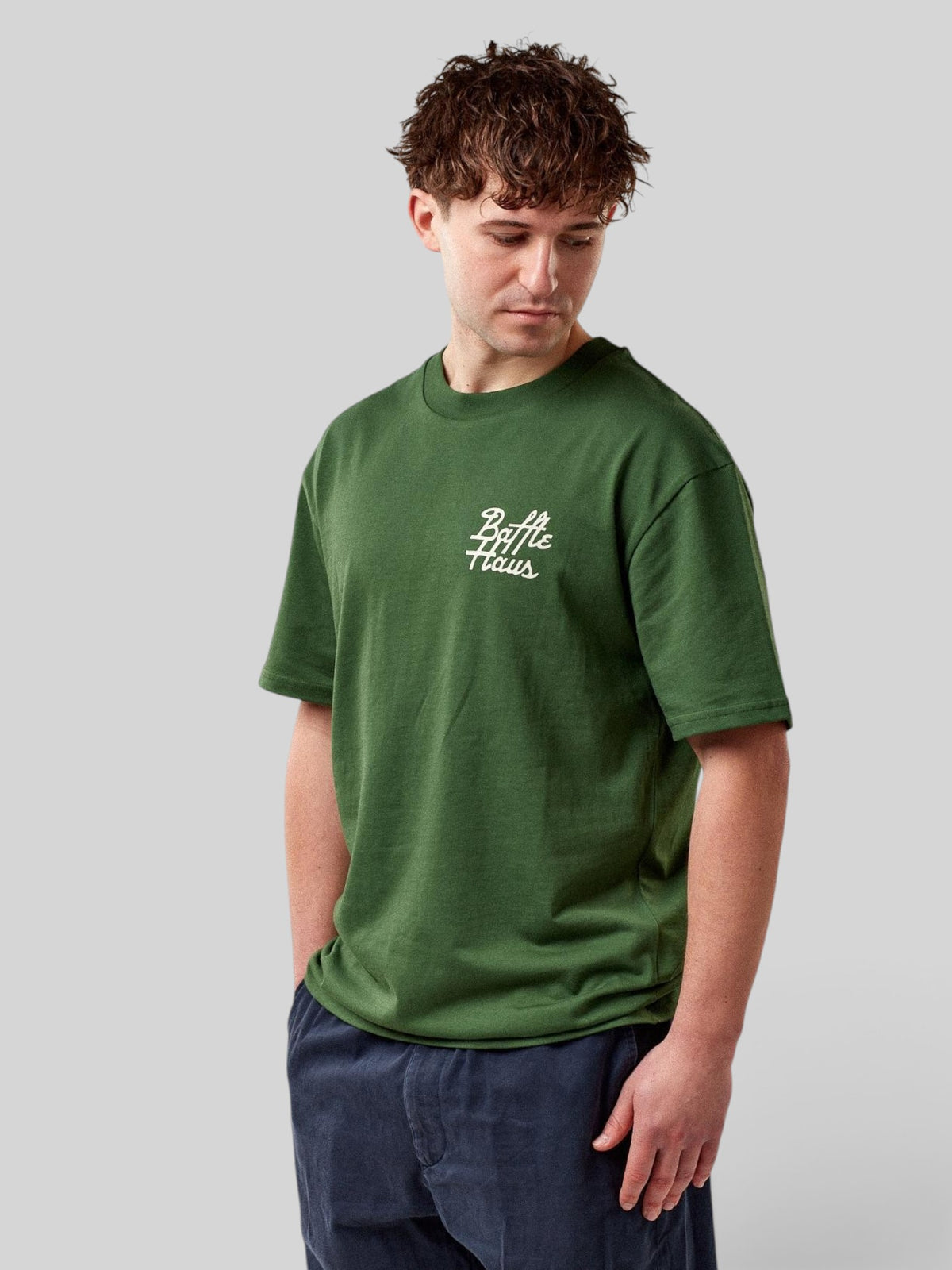 Baffle Haus Mustang Tee in forest green cotton with white chest logo worn by a male model