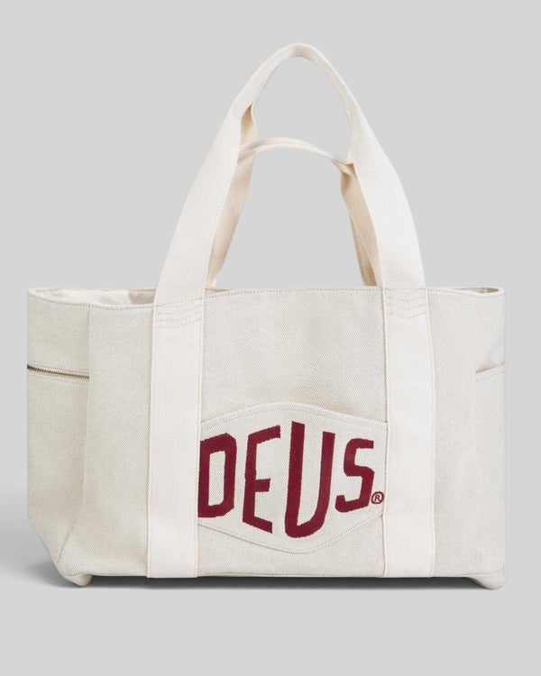 Baffle Haus natural heavyweight cotton canvas beach tote with red embroidered logo patch and gold zip detailing.