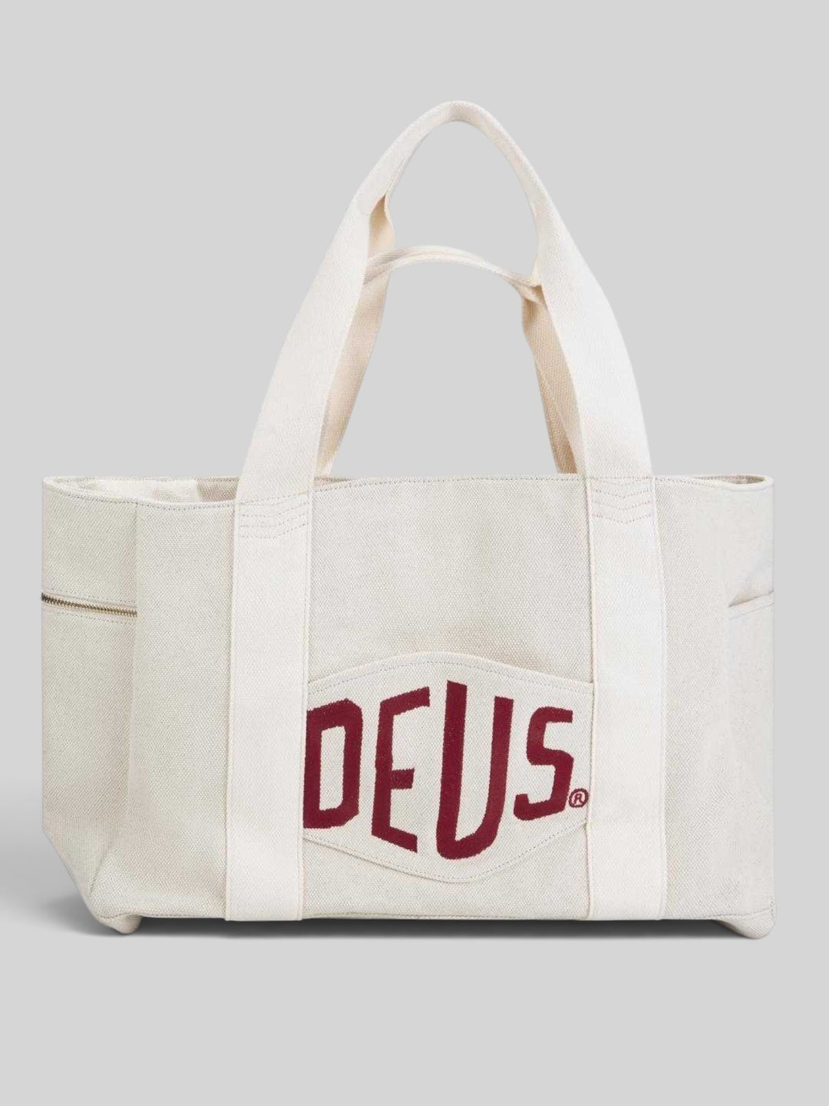 Baffle Haus natural heavyweight cotton canvas beach tote with red embroidered logo patch and gold zip detailing.