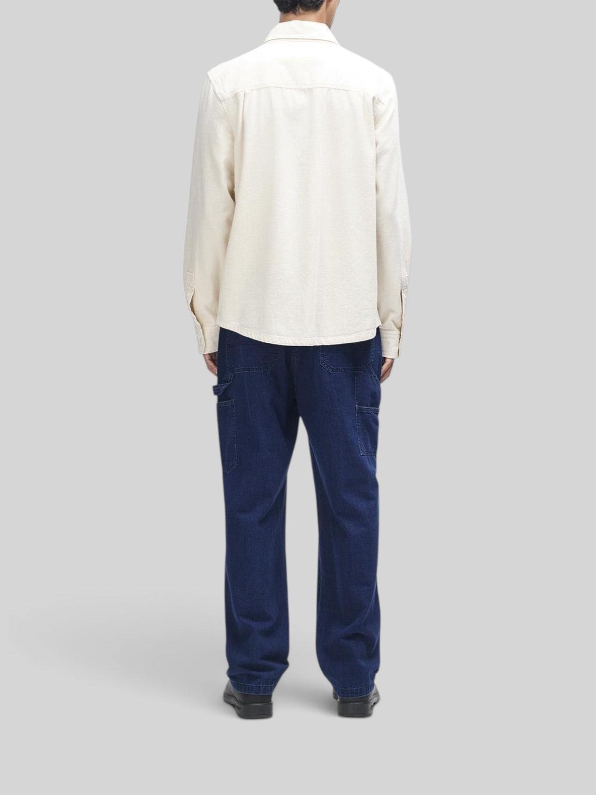 Baffle Haus Vacay Chambray Shirt in natural cotton worn with dark blue denim workwear trousers, back view