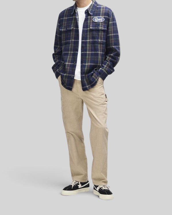 Baffle Haus Vacay navy check brushed cotton flannel shirt with embroidered chest patch worn over a white t-shirt