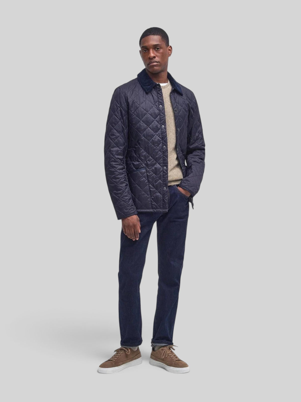 Baffle Haus Heritage Liddesdale navy quilted jacket with corduroy collar worn by a man in jeans and sneakers