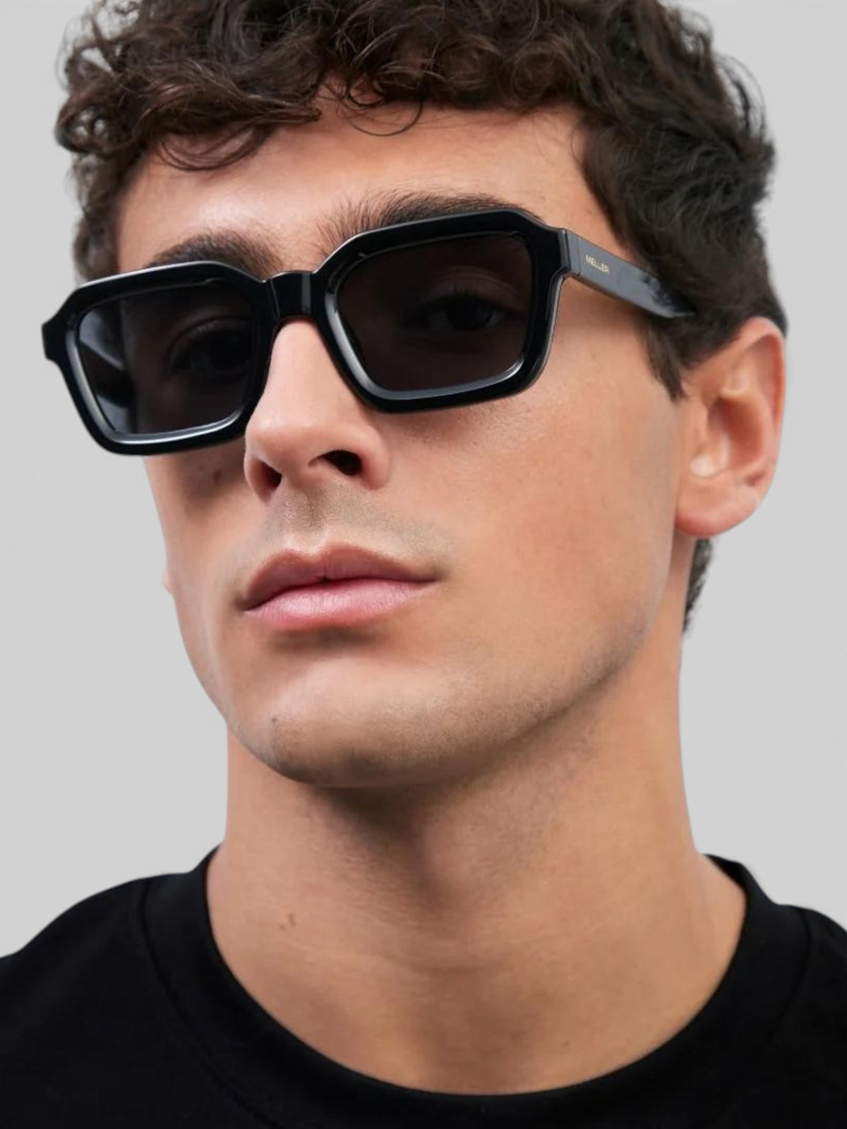 Baffle Haus NAYAH black bio acetate sunglasses with squared frames worn by a man in a studio setting