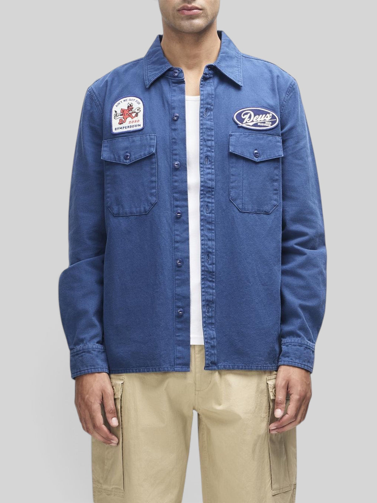 Baffle Haus Nomad shirt in mechanic blue cotton twill with embroidered patches and chest pockets on a male model