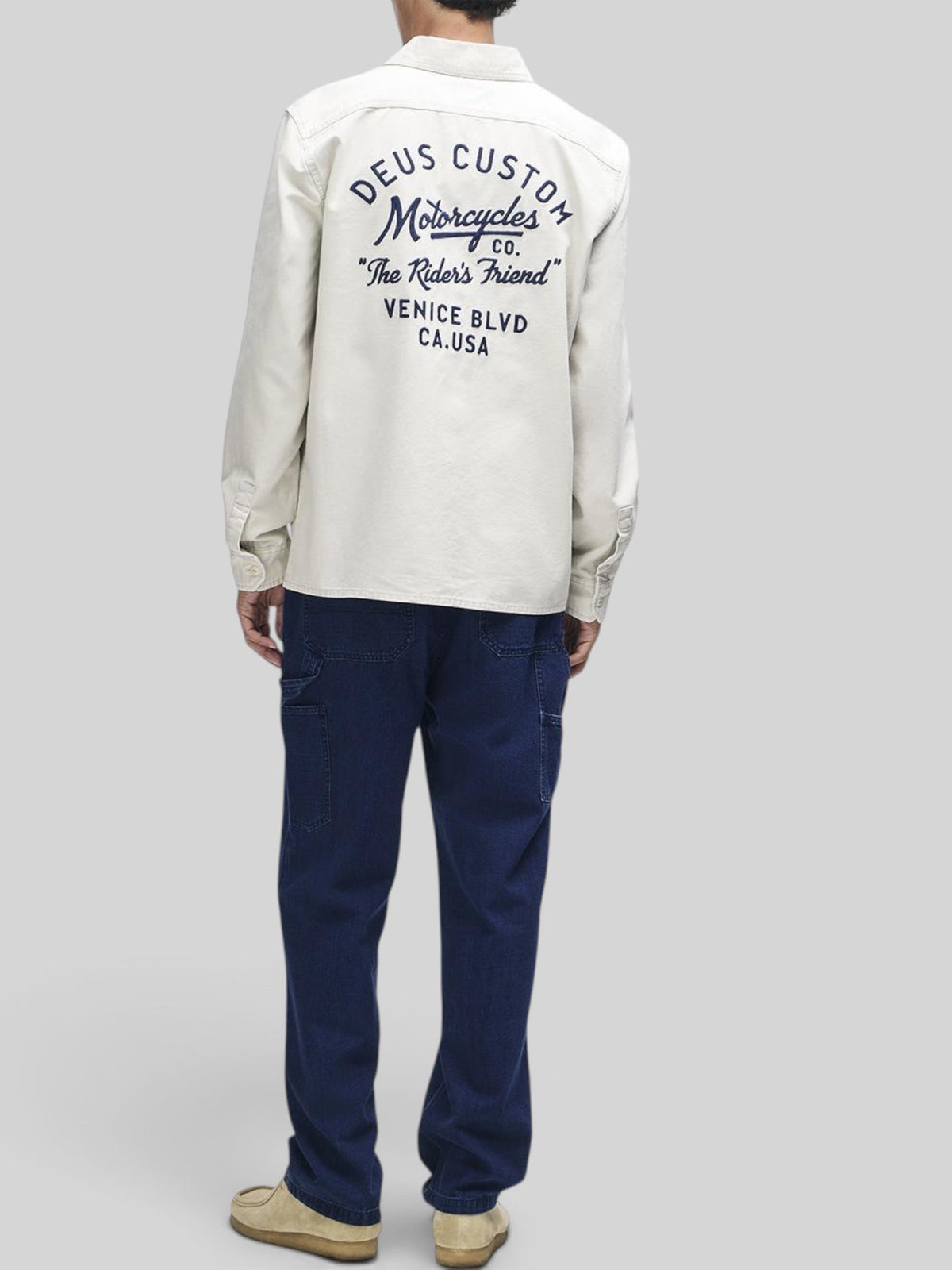 Baffle Haus Nomad shirt in dirty white cotton twill with back embroidery, worn with dark blue jeans