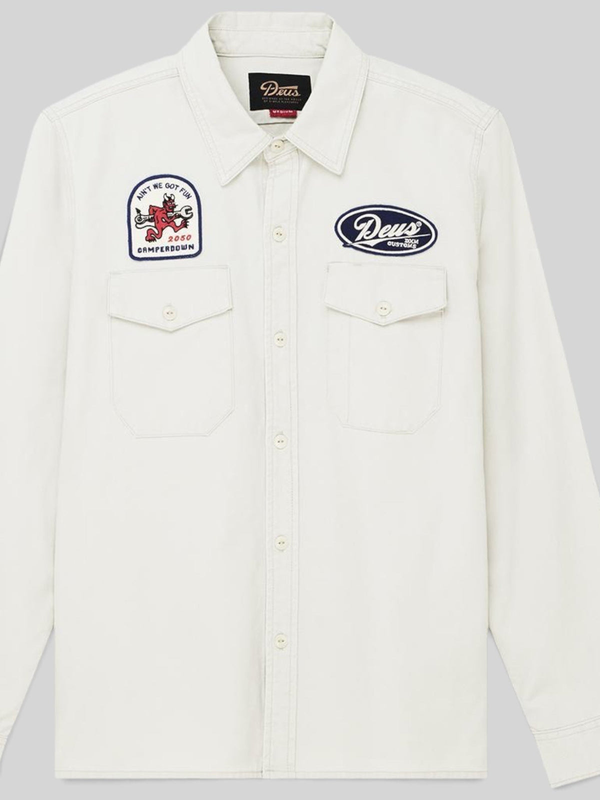 Baffle Haus Nomad shirt in dirty white cotton twill with embroidered patches, chest pockets, and button closure.